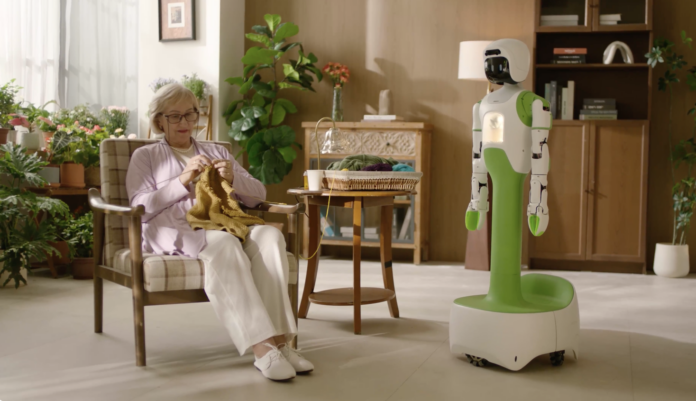 Koko AI home companion robot standing beside an older adult knitting in a living room